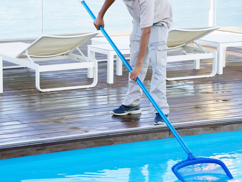 Hombre de mantenimiento limpiando piscina